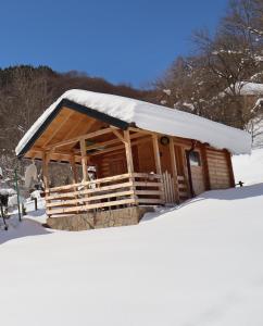 a cabin with a snow covered roof in the snow at Vikendica Mijajlović 2 in Kuršumlija