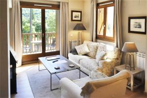 a living room with a couch and a table at Chardín de Llum-Apartamentos Chardins in Benasque