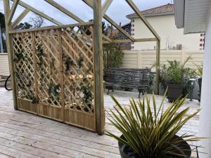 a wooden privacy fence with a bench on a patio at La cabine du 3MA in Lanton