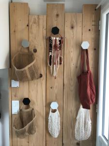 a wooden wall with baskets and purses on it at La cabine du 3MA in Lanton