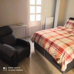 a bedroom with a bed and a chair at MI CASA EN VOLOS in Volos