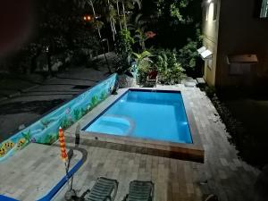 a swimming pool in a backyard at night at Pousada Pier36 in Peruíbe