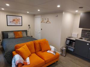 a bedroom with a bed and a couch in it at The Den - Modern cabin with wood burning stove in Ludchurch