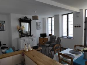 een woonkamer met een tafel en stoelen en een spiegel bij Gîte Au Cœur de Cassel in Cassel