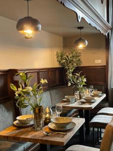 a dining room with two tables with plates and glasses at Hotel Jägerhof in Coesfeld