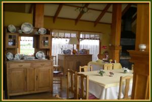 comedor con 2 mesas y cocina en Hosteria Lago del Toro, en Torres del Paine