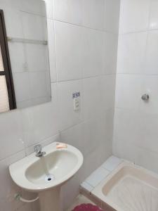 a white bathroom with a sink and a tub at Hostal La Realeza in Potosí +22 photos