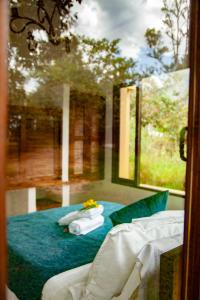 a bedroom with a bed with pillows and a window at Clavellino House Campestre-Villa de Leyva-WIFI in Villa de Leyva
