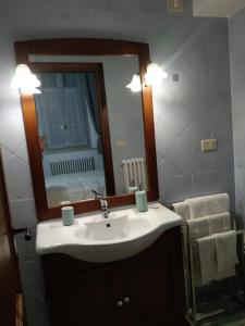 ein Badezimmer mit einem weißen Waschbecken und einem Spiegel in der Unterkunft Dietro le quinte nel cuore di Perugia in Perugia