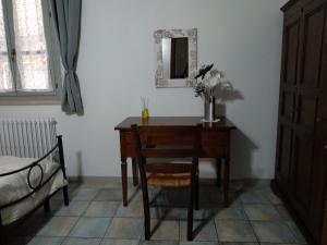 a desk with a vase of flowers and a mirror at Dietro le quinte nel cuore di Perugia in Perugia