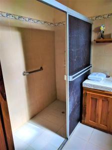a shower with a glass door in a bathroom at Hostal Doña Maria in Pedasí Town