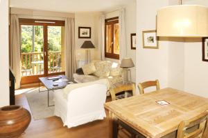 a living room with a table and a couch at Chardín de Llum-Apartamentos Chardins in Benasque