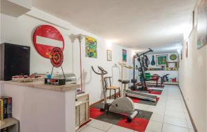 een kamer met een fitnessruimte met fitnessapparatuur aan de muur bij Paucca 1 in San Valentino di Villa