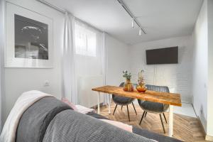 a living room with a table and a couch at Apartamenty MUNN 1 Szczecin in Szczecin