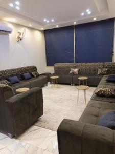 a living room with couches and tables in a room at فيلا مطل الهدا in Al Hada