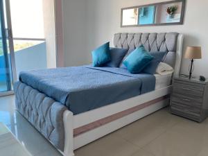 ein Schlafzimmer mit einem großen Bett mit blauen Kissen in der Unterkunft Pozos Colorados Santa Marta - Apartamento 1005 hermosa vista in Santa Marta