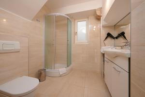 a bathroom with a shower and a toilet and a sink at Palace Central Square in Trogir