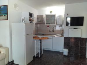 a kitchen with a white refrigerator and a table at La graciosa in Costa Del Silencio