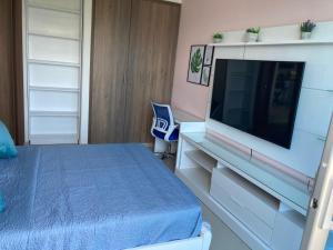 ein Schlafzimmer mit einem Bett und einem Flachbildfernseher in der Unterkunft Pozos Colorados Santa Marta - Apartamento 1005 hermosa vista in Santa Marta