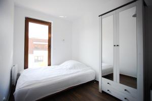 a bedroom with a white bed and a mirror at Lazurowa Fala-2021, Baltic Park in Stegna