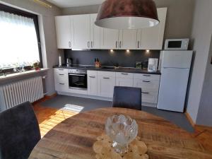 een keuken met een houten tafel en een witte koelkast bij Rainer´s Rheinblick in Oberdiebach