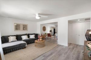 ein Wohnzimmer mit einer schwarzen Couch und einem Tisch in der Unterkunft Cozy Boho Mesa Home with Diving Pool! in Mesa