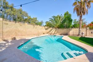 einen Pool im Hinterhof mit einem Zaun und Palmen in der Unterkunft Cozy Boho Mesa Home with Diving Pool! in Mesa