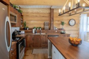 a kitchen with wooden walls and a counter with oranges on it at Breathtaking log house with HotTub - Winter paradise in Tremblant in Saint-Faustin
