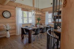 a dining room with a table and chairs and a clock at Breathtaking log house with HotTub - Winter paradise in Tremblant in Saint-Faustin +35 photos