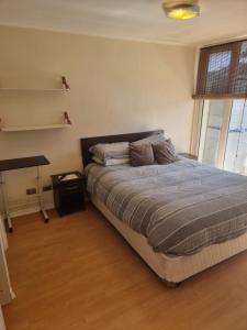 1 dormitorio con cama, mesa y ventana en Precioso apartamento 1D+1B // Jumbo+centro 5 min, en Puerto Montt