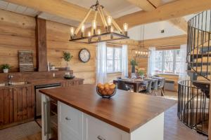 una cucina con tavolo e cesto di frutta di Breathtaking log house with HotTub - Summer paradise in Tremblant a Saint-Faustin