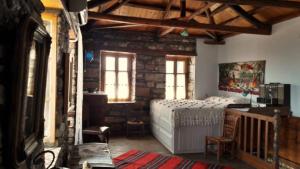 a bedroom with a bed and a table and windows at Traditional House Ekaterini Alonissos in Alonnisos