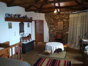a living room with a table and a stone wall at Traditional House Ekaterini Alonissos in Alonnisos