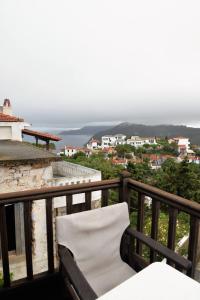 a white chair sitting on a balcony with a view at Traditional House Ekaterini Alonissos in Alonnisos