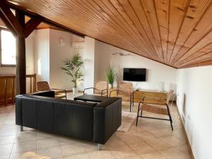 a living room with a black couch and a table at Modern & Comfy Sea View House NG in Portorož