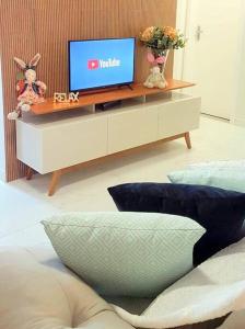 uma televisão sentada numa mesa numa sala de estar em Apartamento CONFORTO prox do SHOPPING NAÇÕES prox ABBA Church - cozinha completa - Ar condicionado - WiFi - Smart Tv 32' - Youtube e Apps - estacionamento privado - Portaria 24h - Acomoda até 8 pessoas - Anfitriã SuperHost no BNB 5 Estrelas em Criciúma