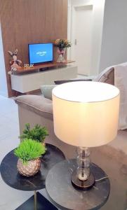 a lamp on a table in a living room at Apartamento CONFORTO prox do SHOPPING NAÇÕES prox ABBA Church - cozinha completa - Ar condicionado - WiFi - Smart Tv 32' - Youtube e Apps - estacionamento privado - Portaria 24h - Acomoda até 8 pessoas - Anfitriã SuperHost no BNB 5 Estrelas in Criciúma