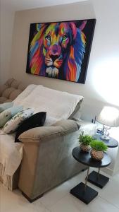 a bedroom with a painting of a lion on the wall at Apartamento CONFORTO CLIMATIZADO prox do SHOPPING NAÇÕES prox ABBA Church - cozinha completa - Ar condicionado - WiFi - Smart Tv 32' - Youtube e Apps - estacionamento privado - Portaria 24h - Acomoda até 8 pessoas - Anfitriã SuperHost no BNB 5 Estrelas in Criciúma
