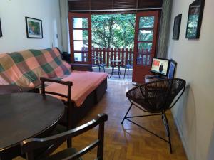 a living room with a bed and a table and chairs at Apartamento Bosque Águas de Lindóia in Águas de Lindoia