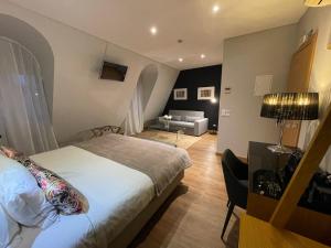 a bedroom with a bed and a living room at Hotel Sete Colinas in Lisbon