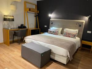 a bedroom with a bed, chair and a lamp at Hotel Sete Colinas in Lisbon