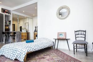 a bedroom with a bed and a chair and a mirror at Superbe T2 de Standing au Pharo - Air Rental in Marseille