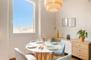 een eetkamer met een tafel en stoelen en een raam bij Splendide appartement sur le cours Estienne d'Orves in Marseille