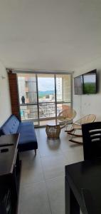 a living room with a blue couch and a large window at Hermoso apartamento en Reserva del peñon in Girardot