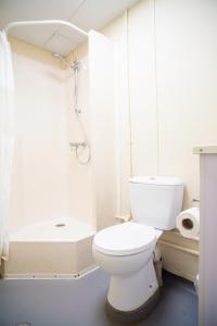 a white bathroom with a toilet and a shower at Green Hills Accommodation Village in Port Moresby