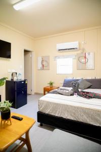 a bedroom with a large bed and a table at Green Hills Accommodation Village in Port Moresby