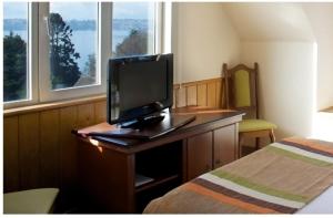 a laptop computer sitting on top of a bed in front of a window at Park Inn by Radisson Puerto Varas in Puerto Varas