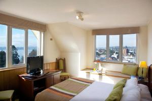1 dormitorio con 1 cama y escritorio con TV en Park Inn by Radisson Puerto Varas, en Puerto Varas