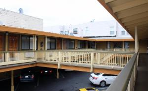 ein Gebäude mit Balkon, auf einem Parkplatz geparkt in der Unterkunft Geary Parkway Motel in San Francisco