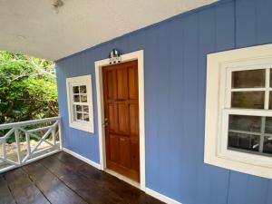 a blue room with a door and two windows at StarFish Apartment in Six Huts